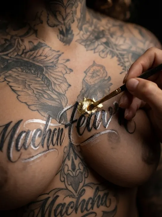 AI image: A brush adding silver script below her chest