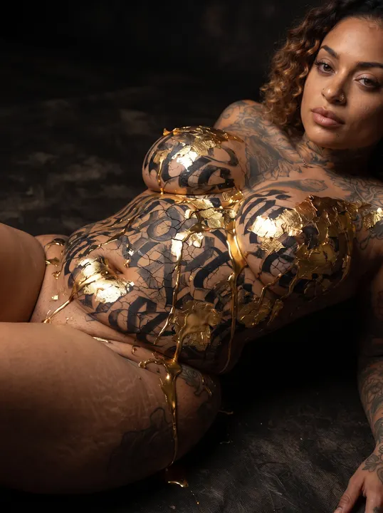 AI image: A woman lying in gold calligraffiti body paint