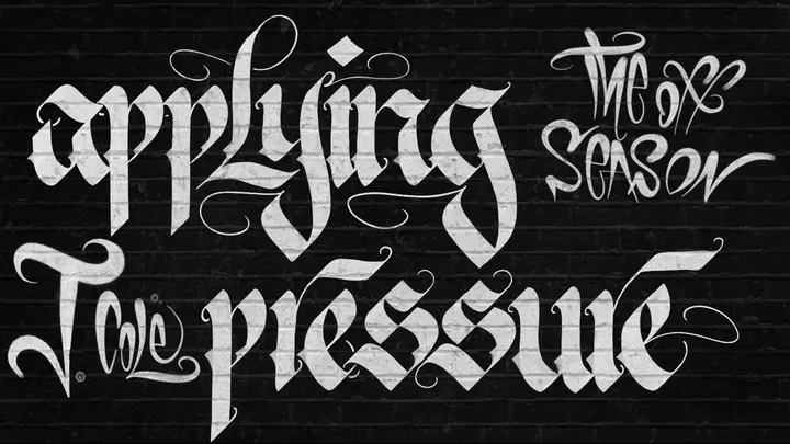 Applying pressure, lettered in white on a dark brick wall