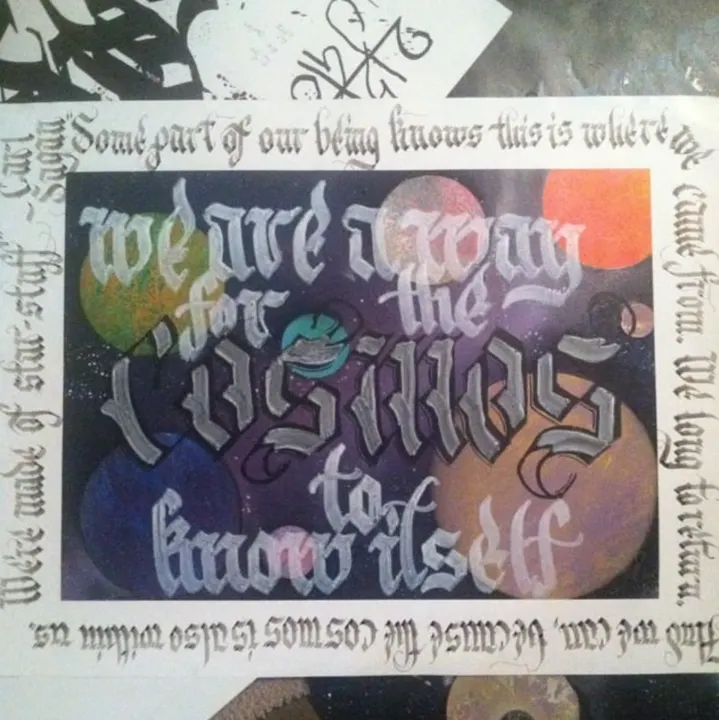We are a way for the cosmos to know itself, lettered over painted planets inside a border of smaller script