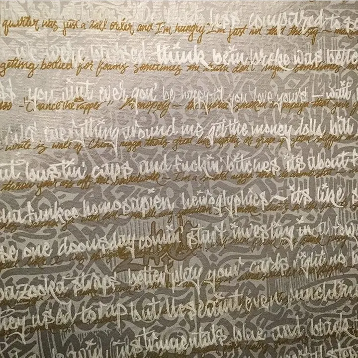 Lines of handwritten lyrics in white and gold stacked across grey paper