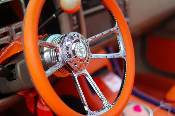 An orange chain steering wheel in a custom car