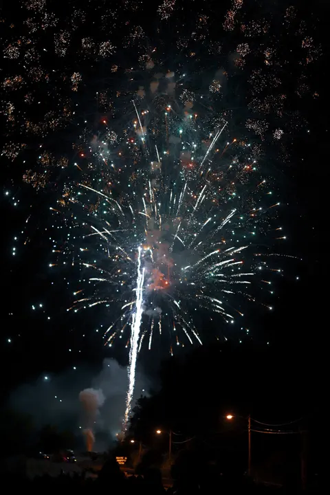 A firework trail bursting into sparks