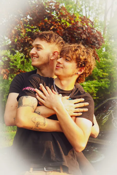 Two young men hugging, with a soft white vignette
