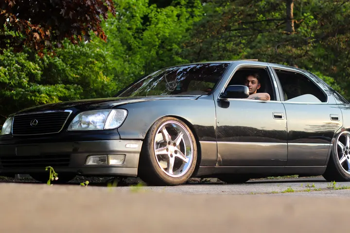 A lowered black Lexus with its driver