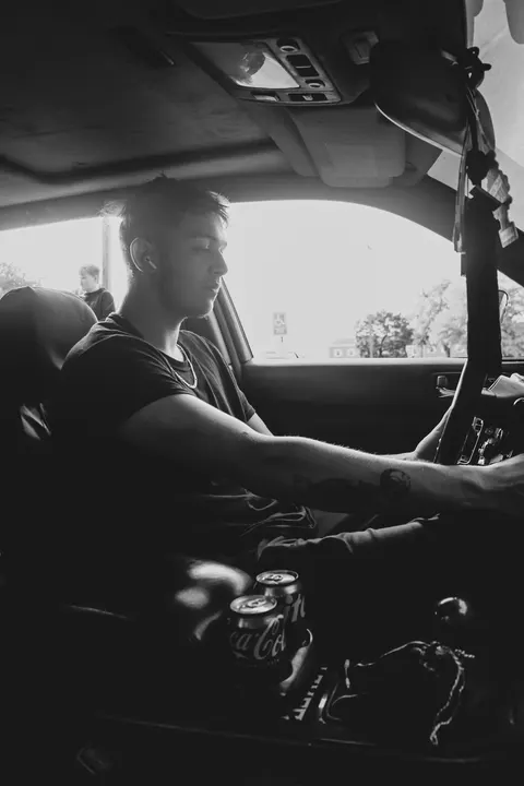 A driver at the wheel, in black and white